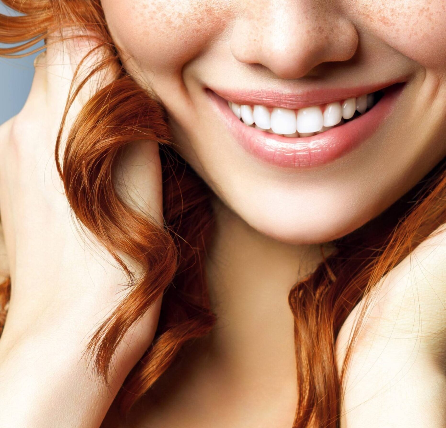 Smiling Woman with White Teeth and Red Curly Hair